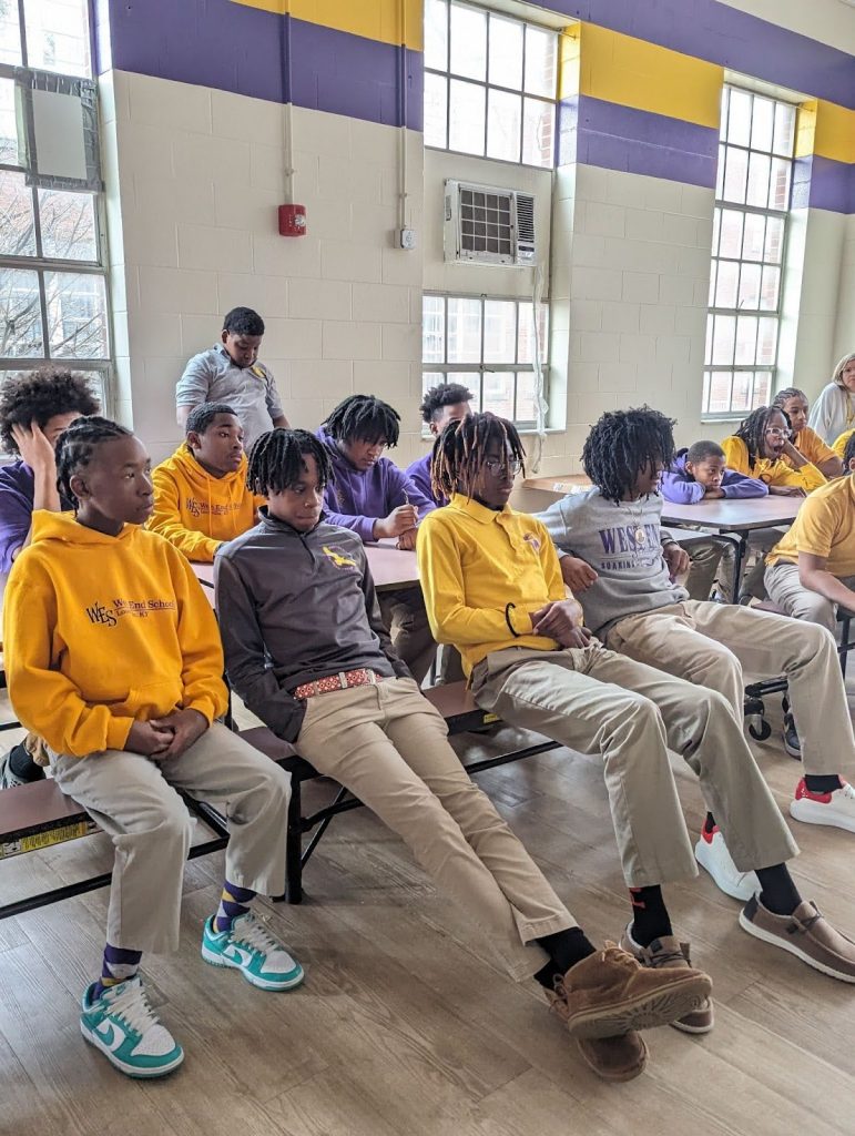 group of children sitting listening to a speaker