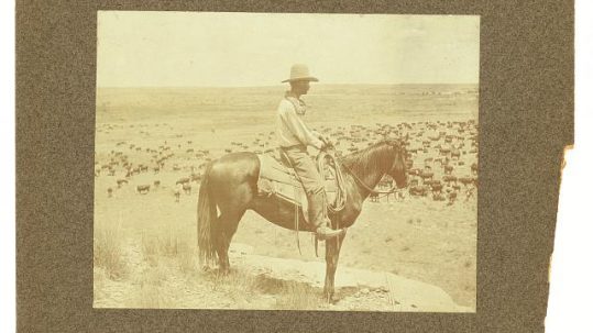 a sepia-toned photo of a man on horseback