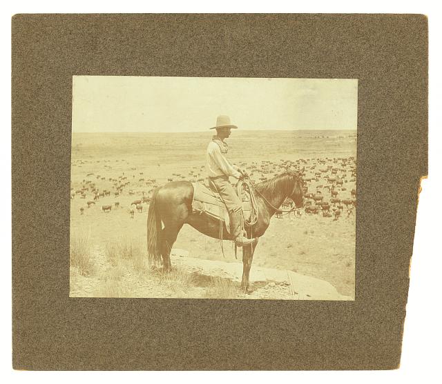 a sepia-toned photo of a man on horseback